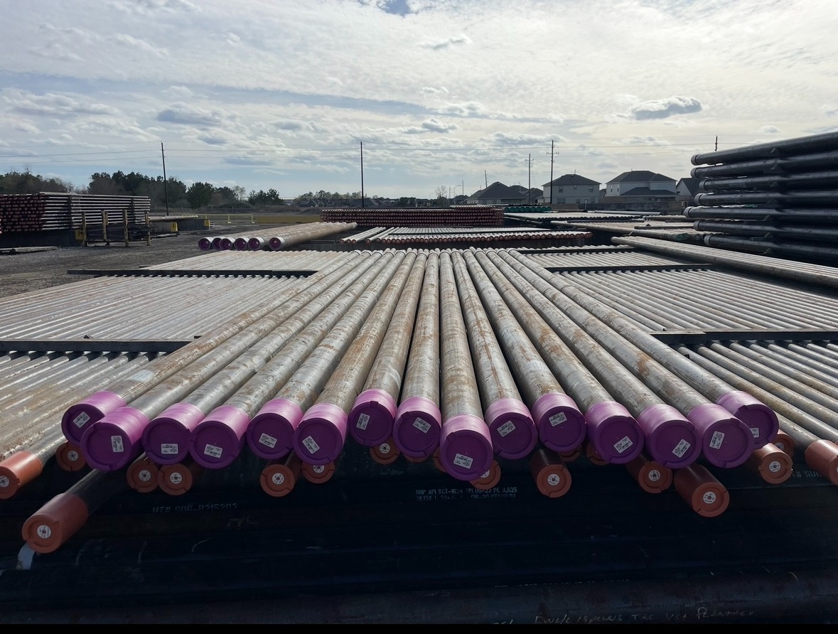 Rows of purple-capped casing pipe staged in the Delta Solutions yard ready for load-out